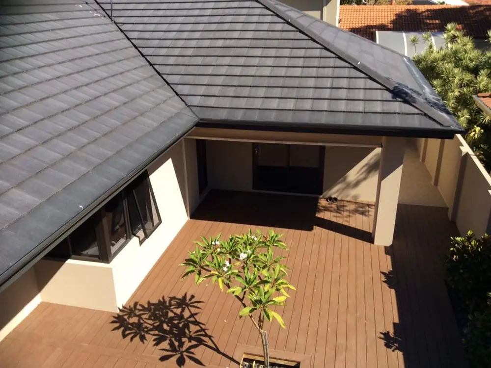 A modern home with a charcoal tiled roof and gutter guard fitted along the full gutter run