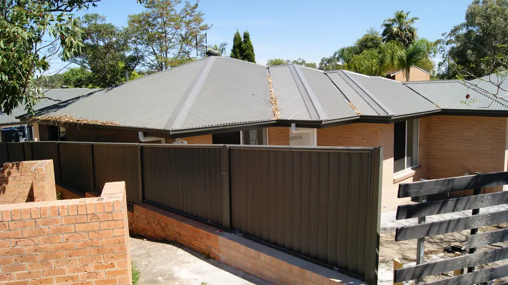 A row of brick homes with gutter mesh fitted along each roofline