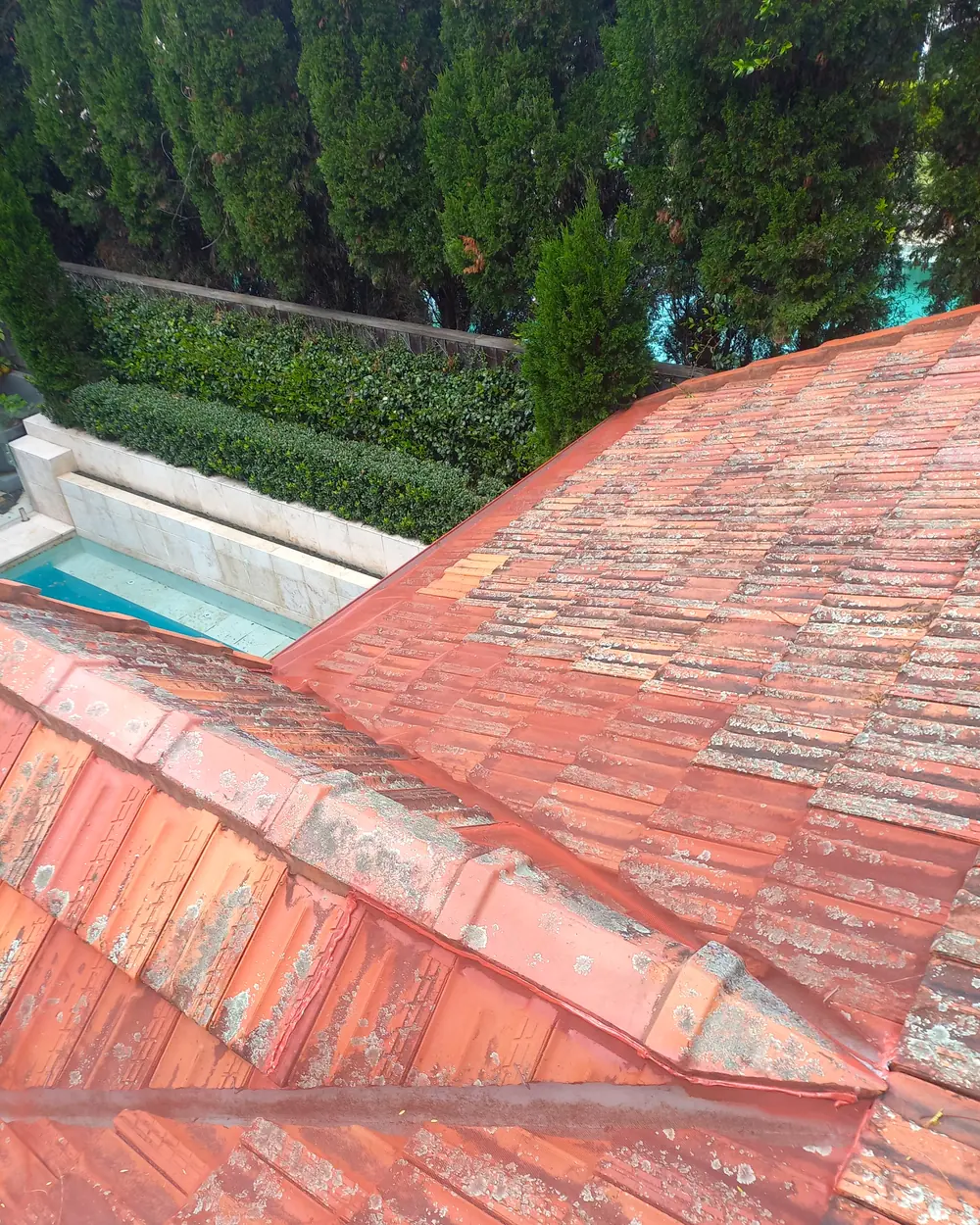 A terracotta tiled roof valley with gutter mesh running the length of the valley line