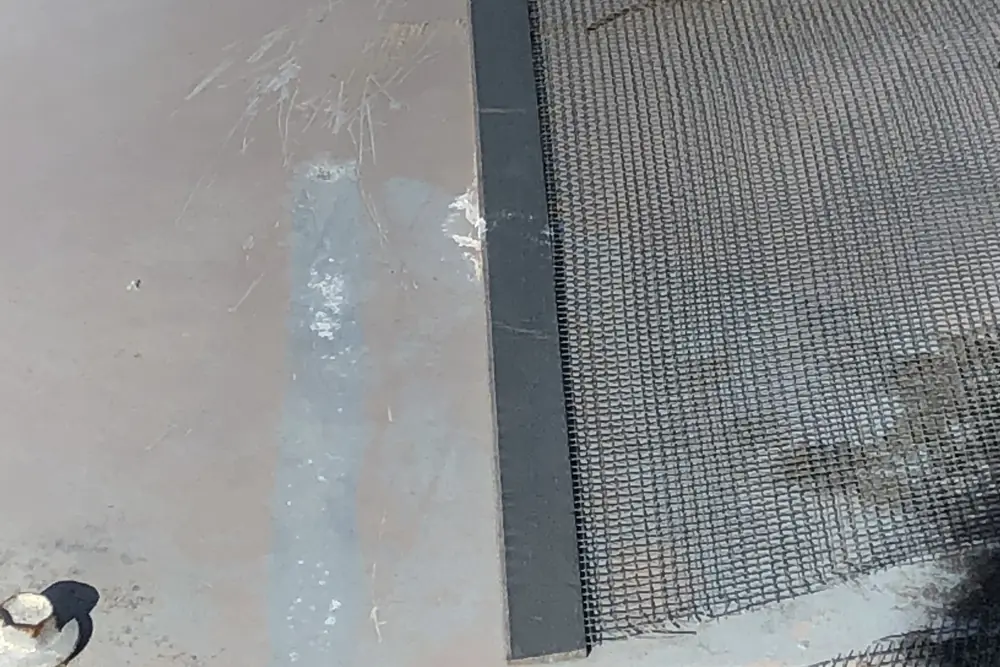 Gutter mesh finished against a wall junction on a commercial roof
