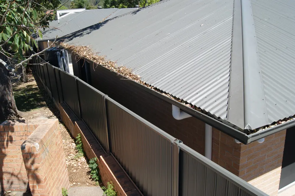 A home with gutter mesh along the eaves and litter held on the surface