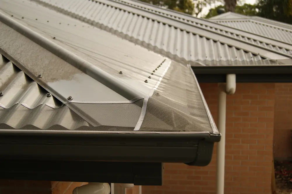 Gutter mesh along the gutter of a cream metal roof
