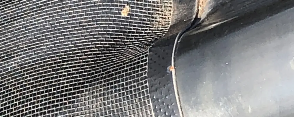 Close view of Leaf Free gutter mesh held at the gutter edge of a corrugated roof