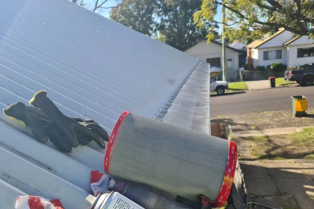 A roll of Leaf Free gutter mesh with its adhesive tape edge, ready to be laid along a roof
